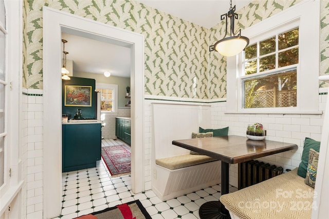 dining area with radiator, breakfast area, and tile walls