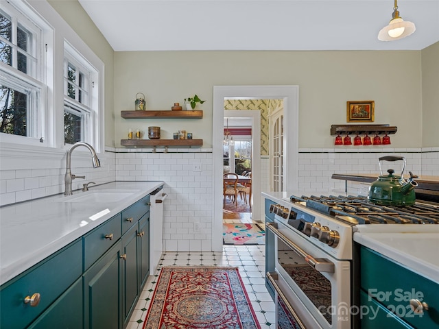 kitchen featuring white appliances, sink, decorative light fixtures, tile walls, and light tile patterned flooring