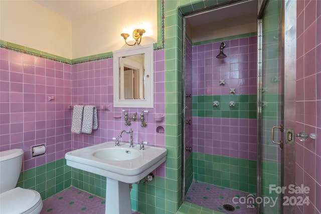 bathroom with an enclosed shower, tile walls, and toilet