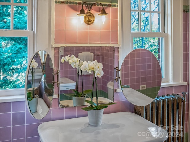 dining space with radiator and tile walls