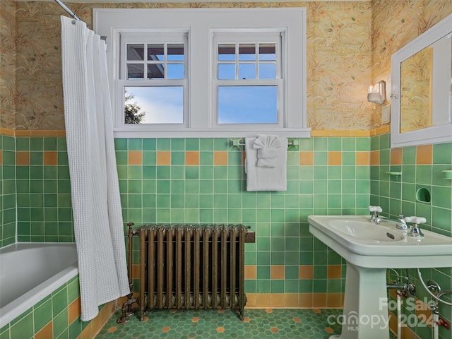 bathroom featuring tile patterned flooring, shower / bath combo with shower curtain, tile walls, and radiator