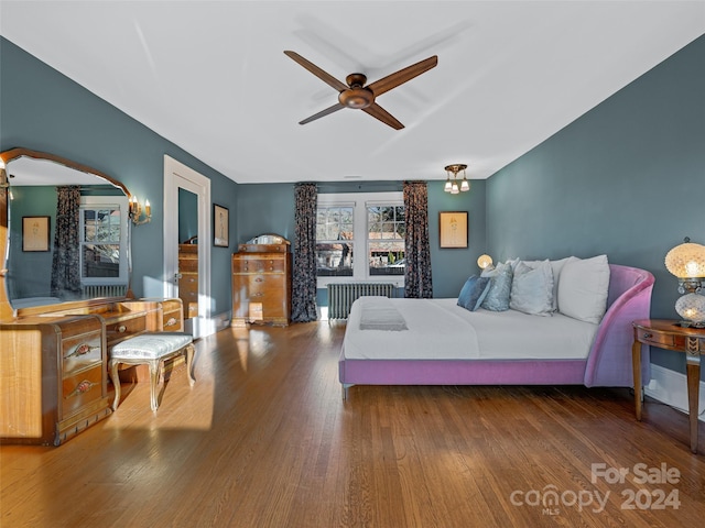 bedroom with hardwood / wood-style flooring, ceiling fan, and radiator heating unit