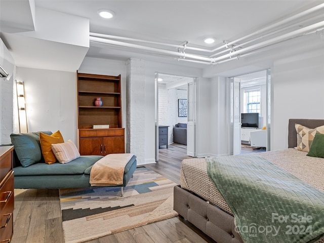 bedroom with wood-type flooring and ensuite bathroom