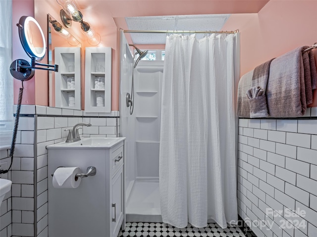 bathroom featuring vanity, curtained shower, and tile walls