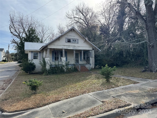 bungalow-style home featuring a porch and a front yard