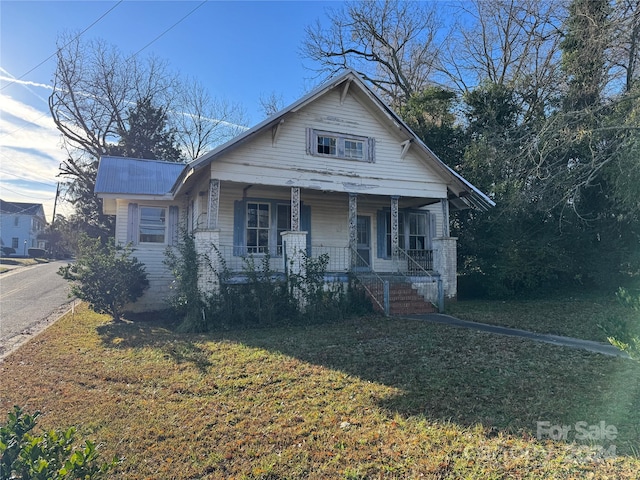 bungalow-style house with covered porch and a front yard