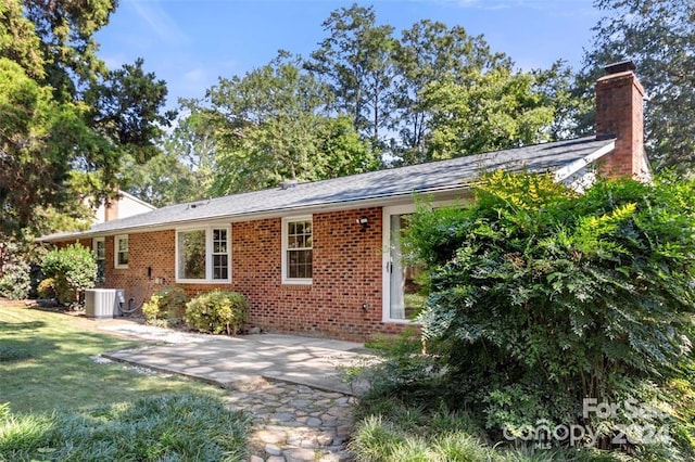 view of front of house with a front yard and central AC unit