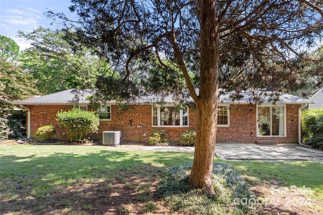 back of property with central air condition unit, a yard, and a patio