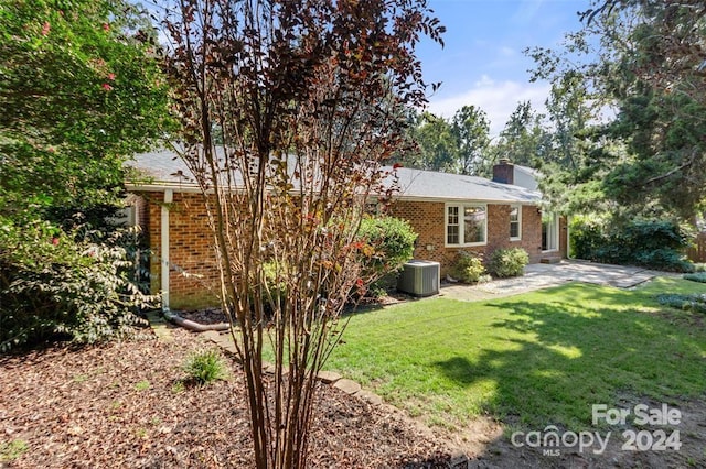 view of front of home with central AC unit and a front yard