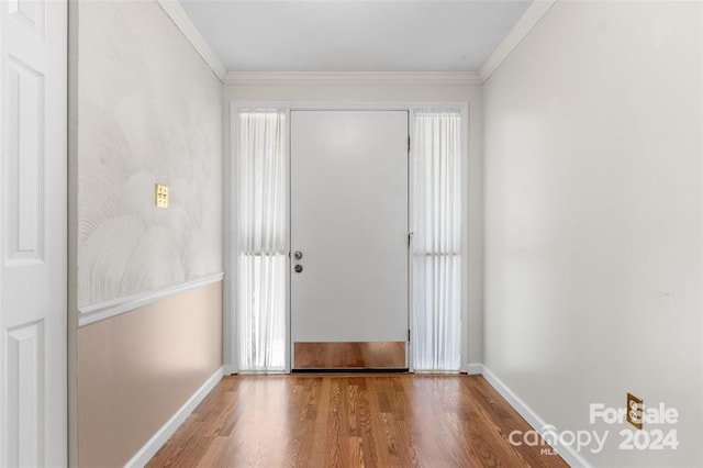 doorway to outside with a healthy amount of sunlight, ornamental molding, and hardwood / wood-style flooring