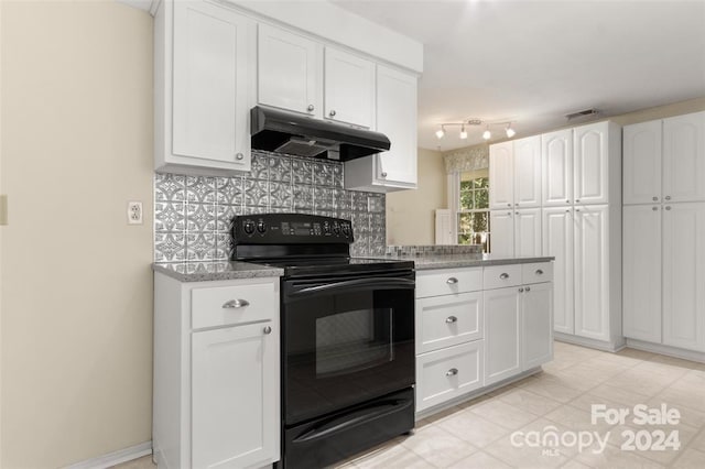 kitchen featuring electric range, tasteful backsplash, white cabinetry, and light stone counters