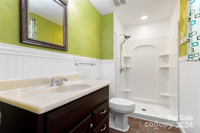 bathroom featuring vanity, toilet, and walk in shower