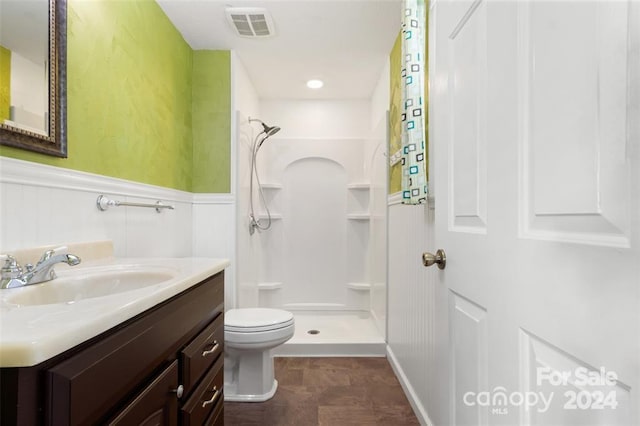 bathroom with toilet, vanity, and walk in shower