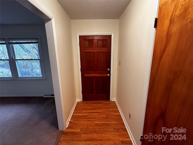 doorway to outside with hardwood / wood-style flooring and a textured ceiling