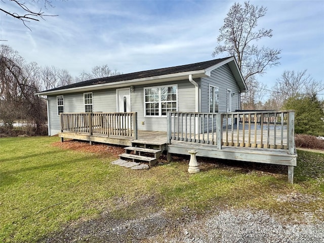 rear view of house with a deck and a lawn