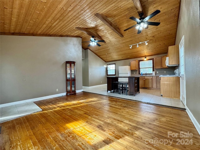 kitchen with a kitchen island, light wood-type flooring, beamed ceiling, white fridge, and wood ceiling