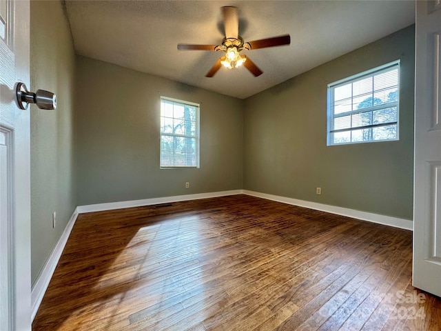 empty room with ceiling fan and dark hardwood / wood-style flooring