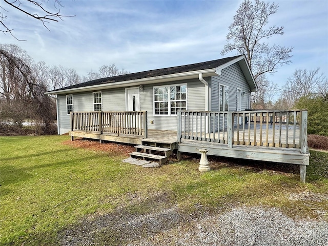 back of house featuring a lawn and a wooden deck