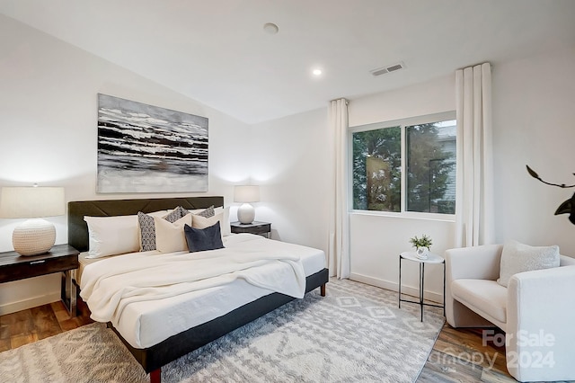 bedroom with wood-type flooring and lofted ceiling