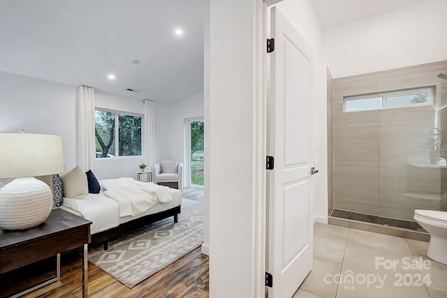 bedroom with light hardwood / wood-style floors and lofted ceiling