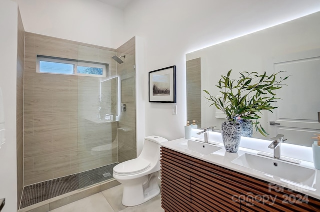 bathroom featuring a tile shower, tile patterned flooring, vanity, and toilet