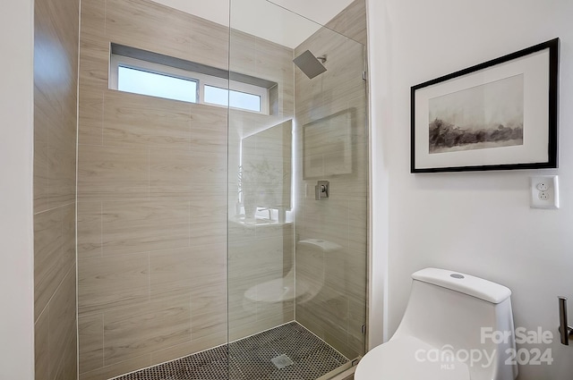 bathroom with a shower with door and toilet