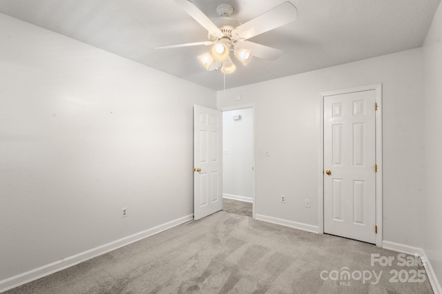 unfurnished bedroom featuring ceiling fan and light carpet