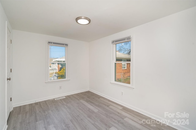 spare room with plenty of natural light and light hardwood / wood-style flooring