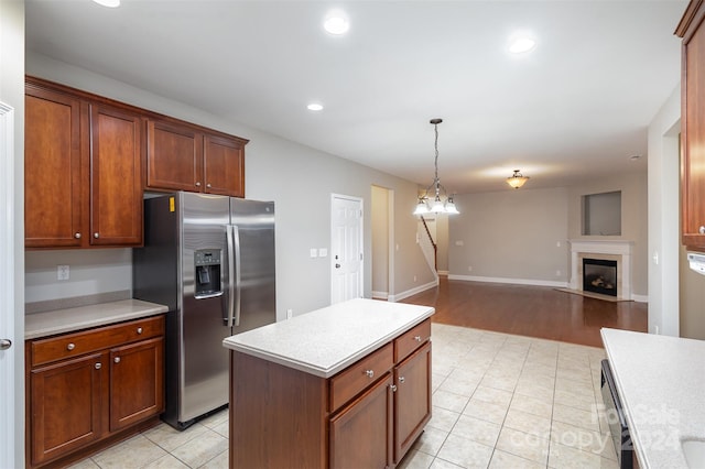 kitchen with stainless steel refrigerator with ice dispenser, a notable chandelier, pendant lighting, dishwashing machine, and a kitchen island