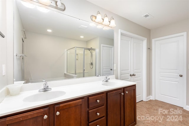 bathroom with tile patterned flooring, vanity, and a shower with door