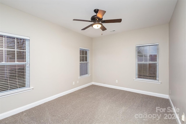 carpeted spare room featuring ceiling fan