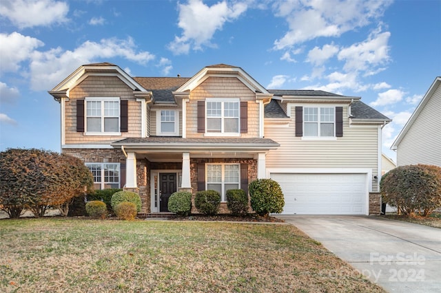 view of front of home with a garage and a front lawn