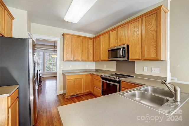 kitchen with sink, stainless steel appliances, and light wood-type flooring