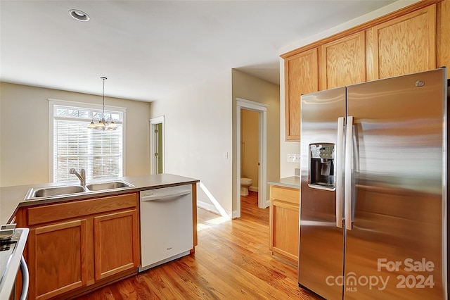 kitchen featuring sink, stainless steel refrigerator with ice dispenser, white dishwasher, a chandelier, and decorative light fixtures