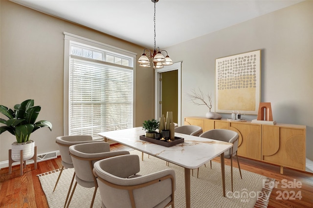 dining area featuring hardwood / wood-style floors and a notable chandelier