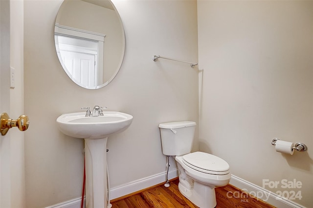 bathroom with hardwood / wood-style floors and toilet