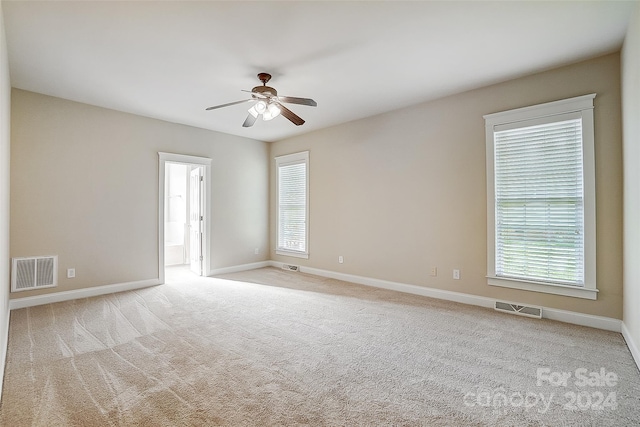 carpeted spare room with ceiling fan