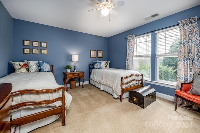 carpeted bedroom with multiple windows and ceiling fan