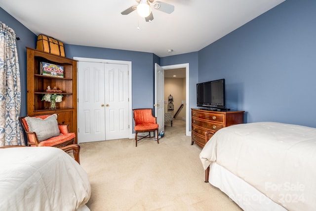 bedroom featuring ceiling fan, a closet, and light carpet