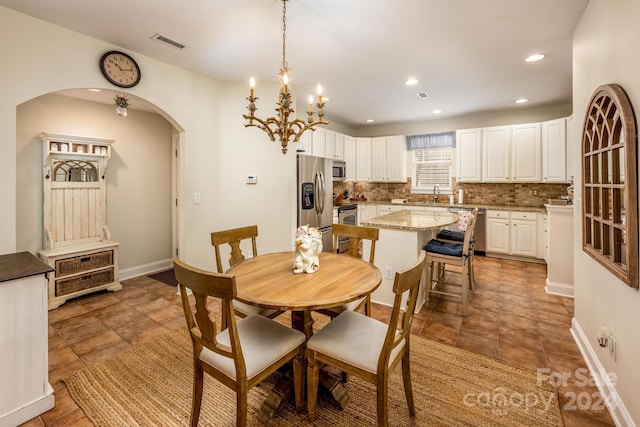 dining space featuring an inviting chandelier and sink