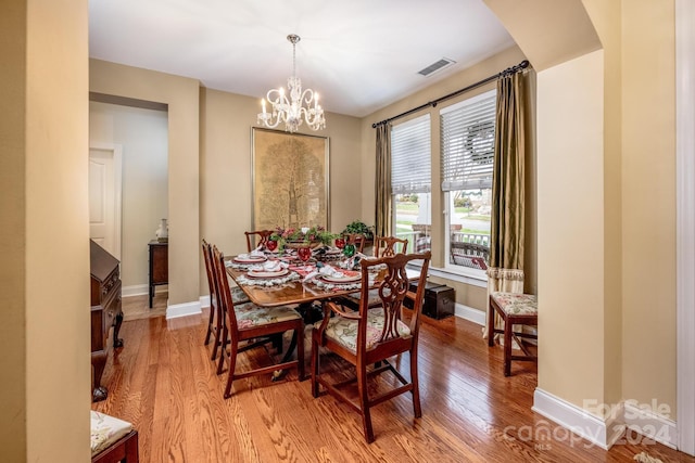 dining space with a chandelier and light hardwood / wood-style flooring