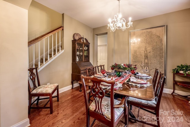 dining room with wood-type flooring and an inviting chandelier