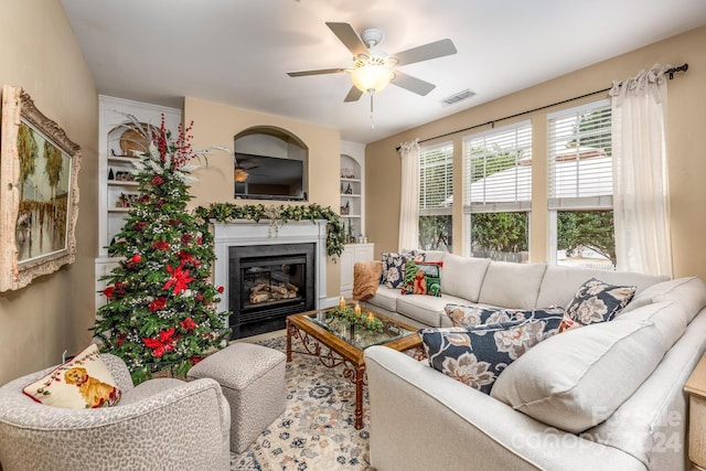 living room featuring ceiling fan and built in features