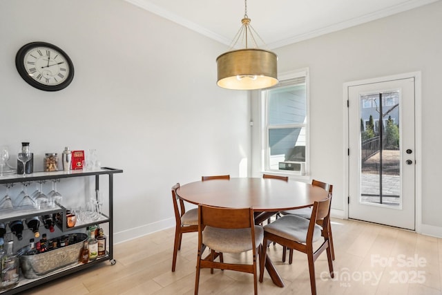 dining area featuring crown molding and light hardwood / wood-style floors