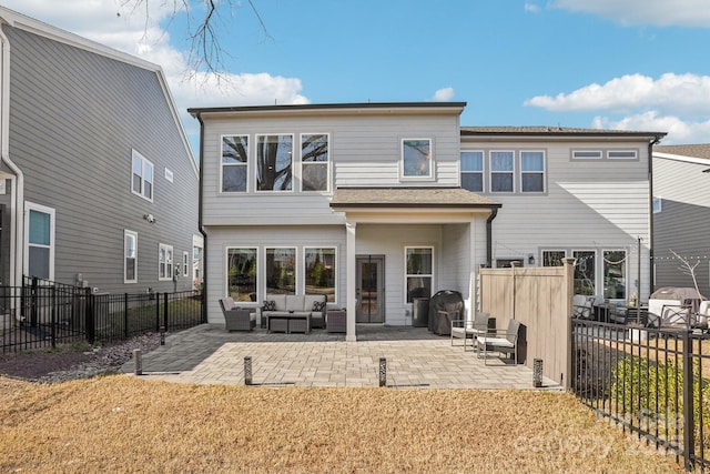 back of house with outdoor lounge area, a patio area, and a lawn