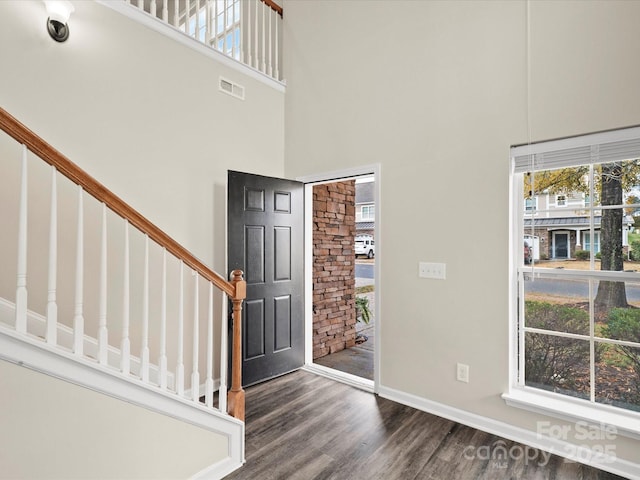 entrance foyer featuring a towering ceiling and dark hardwood / wood-style floors