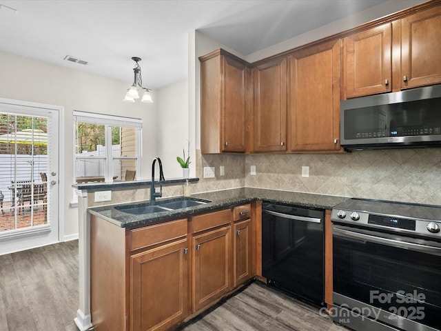 kitchen featuring stainless steel appliances, backsplash, wood-type flooring, and sink