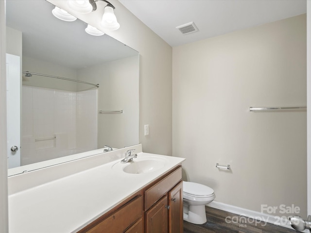 bathroom with toilet, wood-type flooring, vanity, and walk in shower