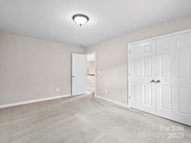 unfurnished bedroom with a closet and light carpet