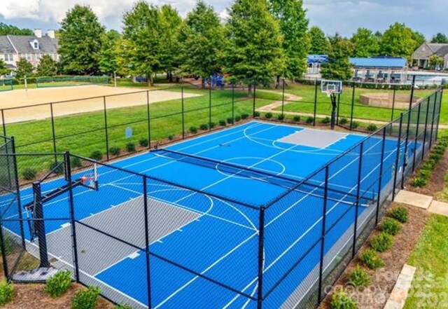 view of sport court with a lawn